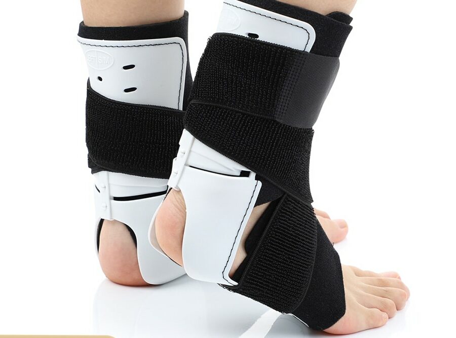 2 protesi ortopediche per la caviglia, bianche e nere su sfondo bianco
